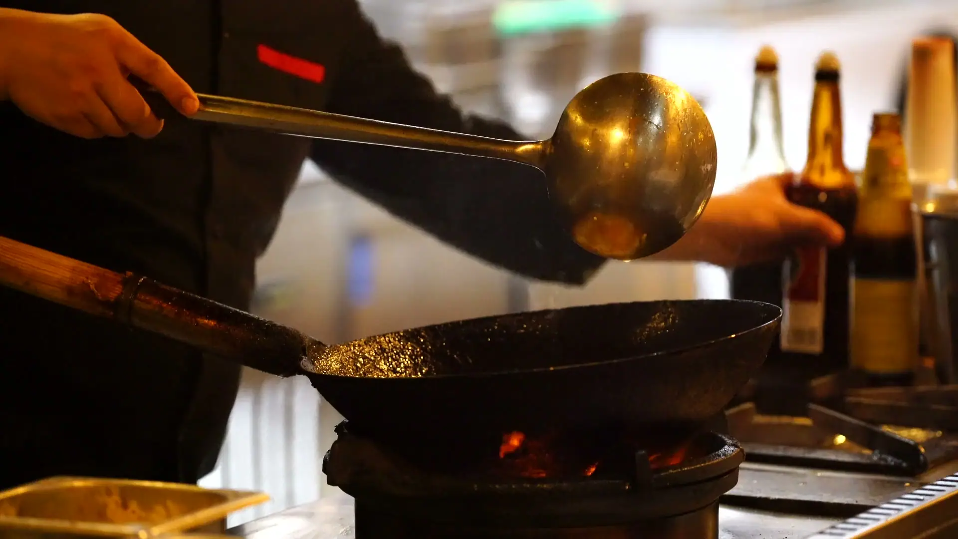 Chef tossing curry in a wok over an open flame at Bombay 2 Goa