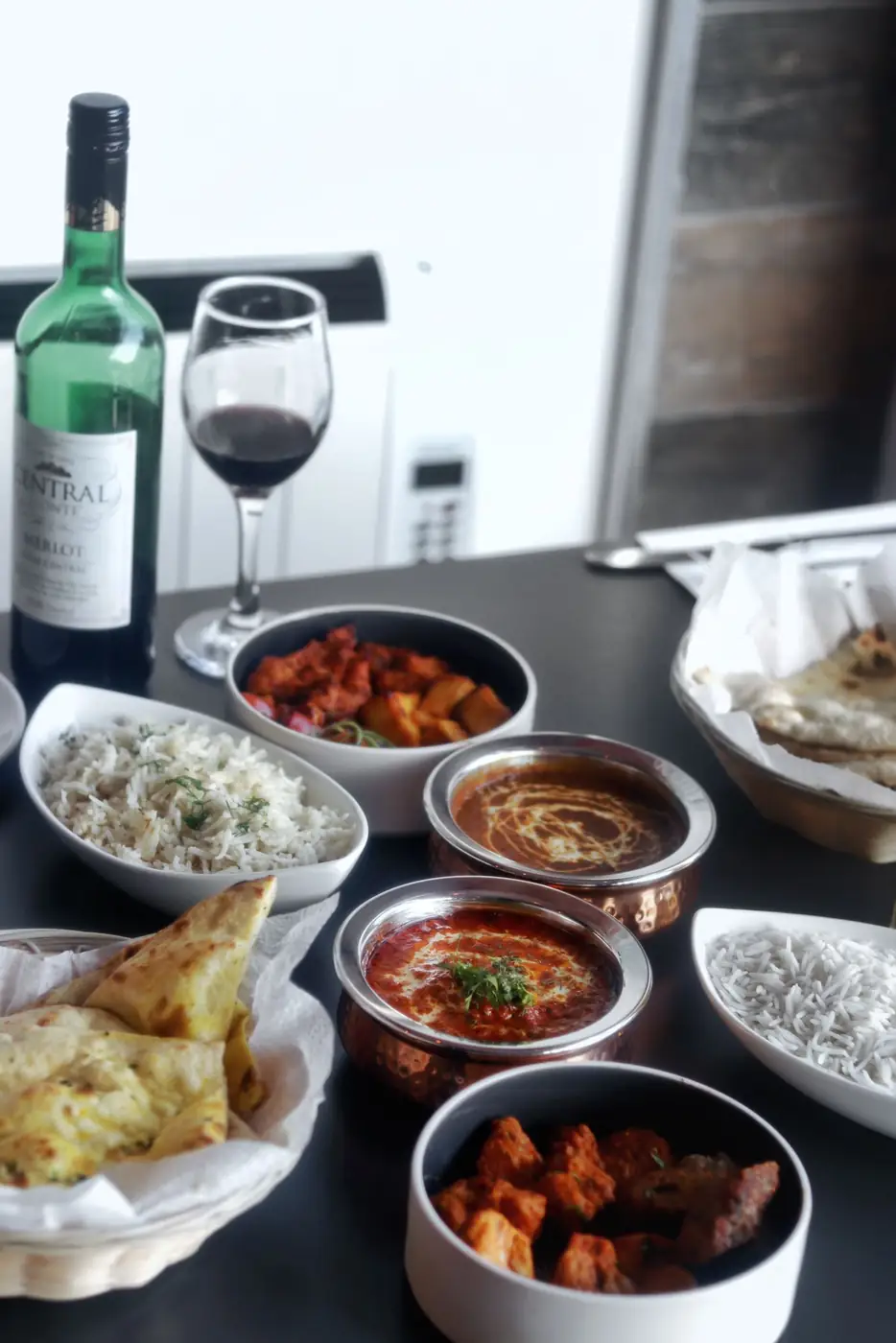 A spread of curries, rice and naan with wine at Bombay 2 Goa