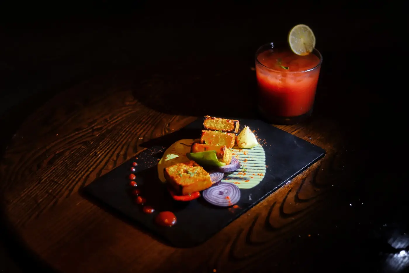 Plated starters and a cocktail served on slate at Bombay 2 Goa