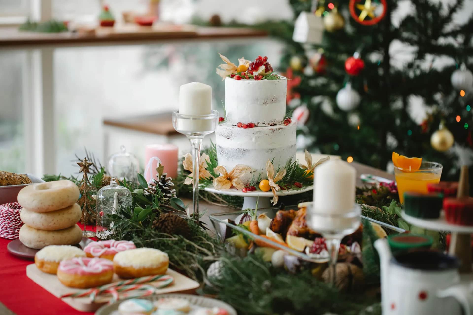 A festive spread of Christmas treats and a roast laid out beside a decorated tree
