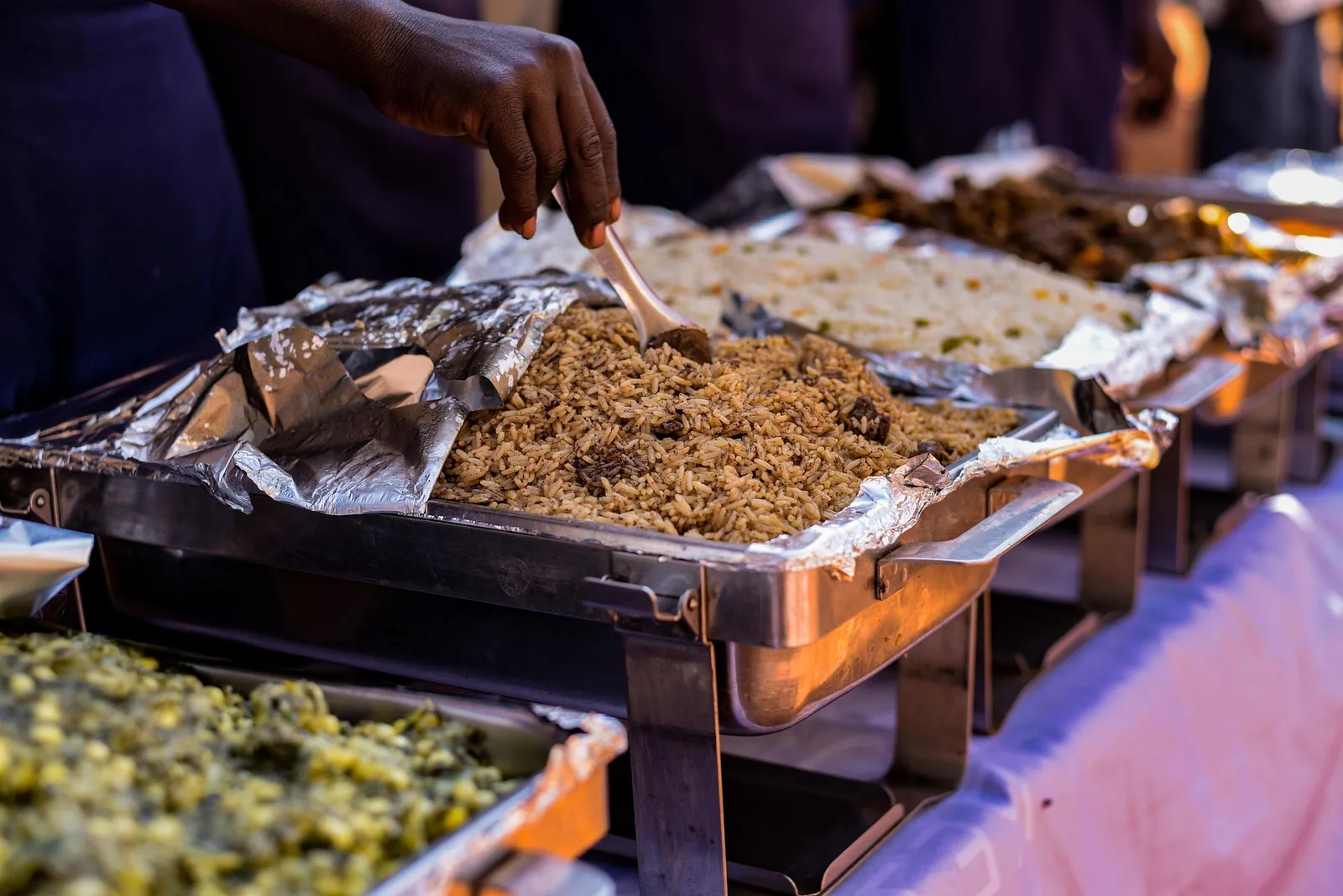 Hot buffet trays of rice and curries on a serving table