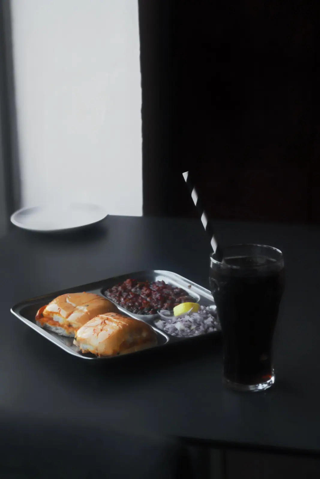 Packaged Bombay 2 Goa meal tray with a drink, ready for drop-off