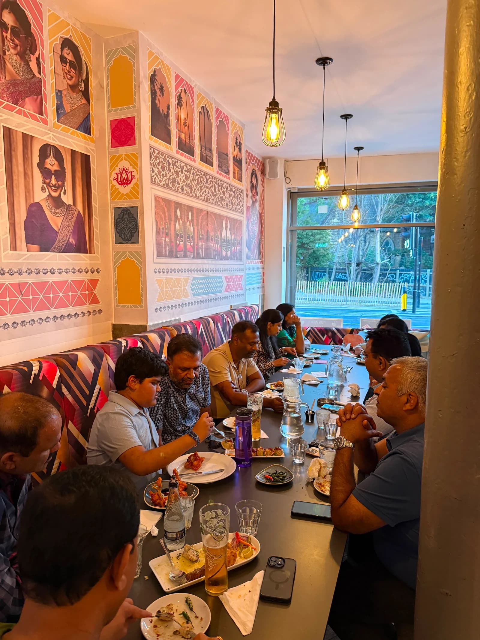 A large group sharing a long table of starters at Bombay 2 Goa
